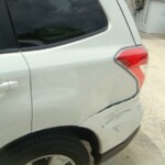 Before and after photographs of a damaged white Subaru that was repaired by Elite Paint & Body Shop in West Palm Beach, Florida